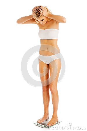 Woman Weighing Herself On Bathroom Scales  Studio Shot On White    