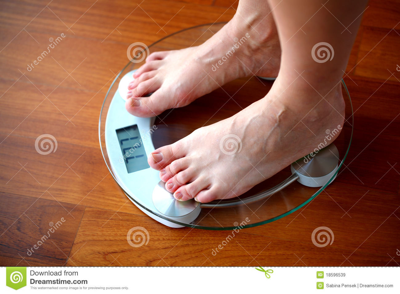 Woman Weighing Herself On The Home Weighing Scale