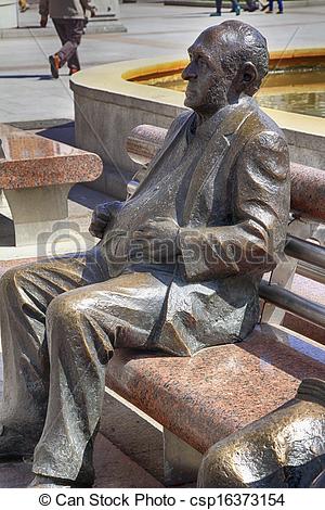 Stock Photo   Bronze Statue Of Man Sitting On A Park Bench   Stock