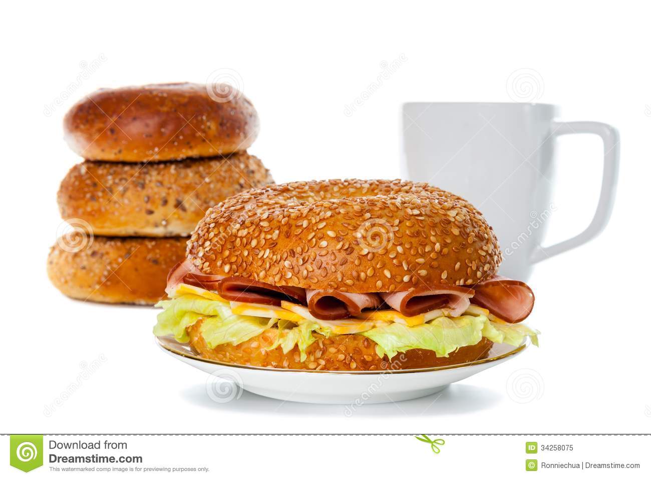 Ham And Cheese Bagel Sandwich On A Plate With Stacks Of Bagel And    