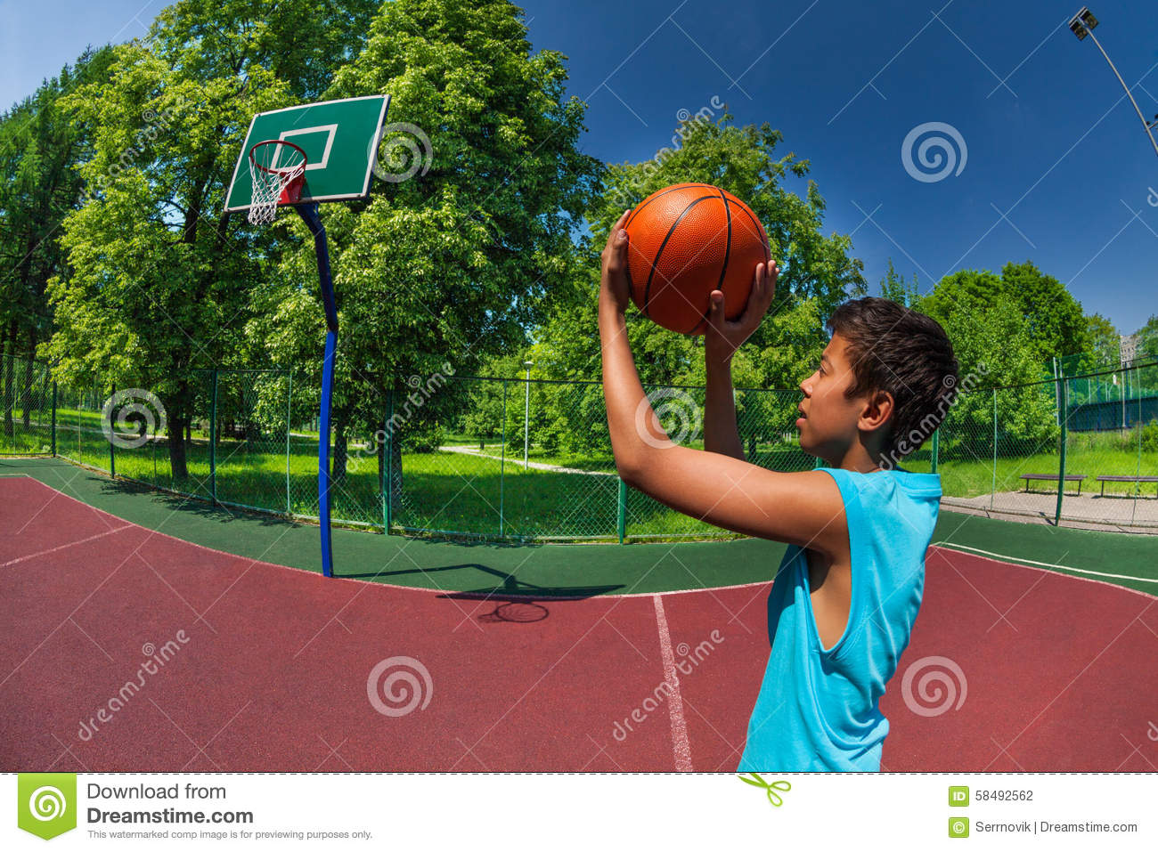 Arabian Boy Throwing Ball In Basketball Goal On The Playground Outside    