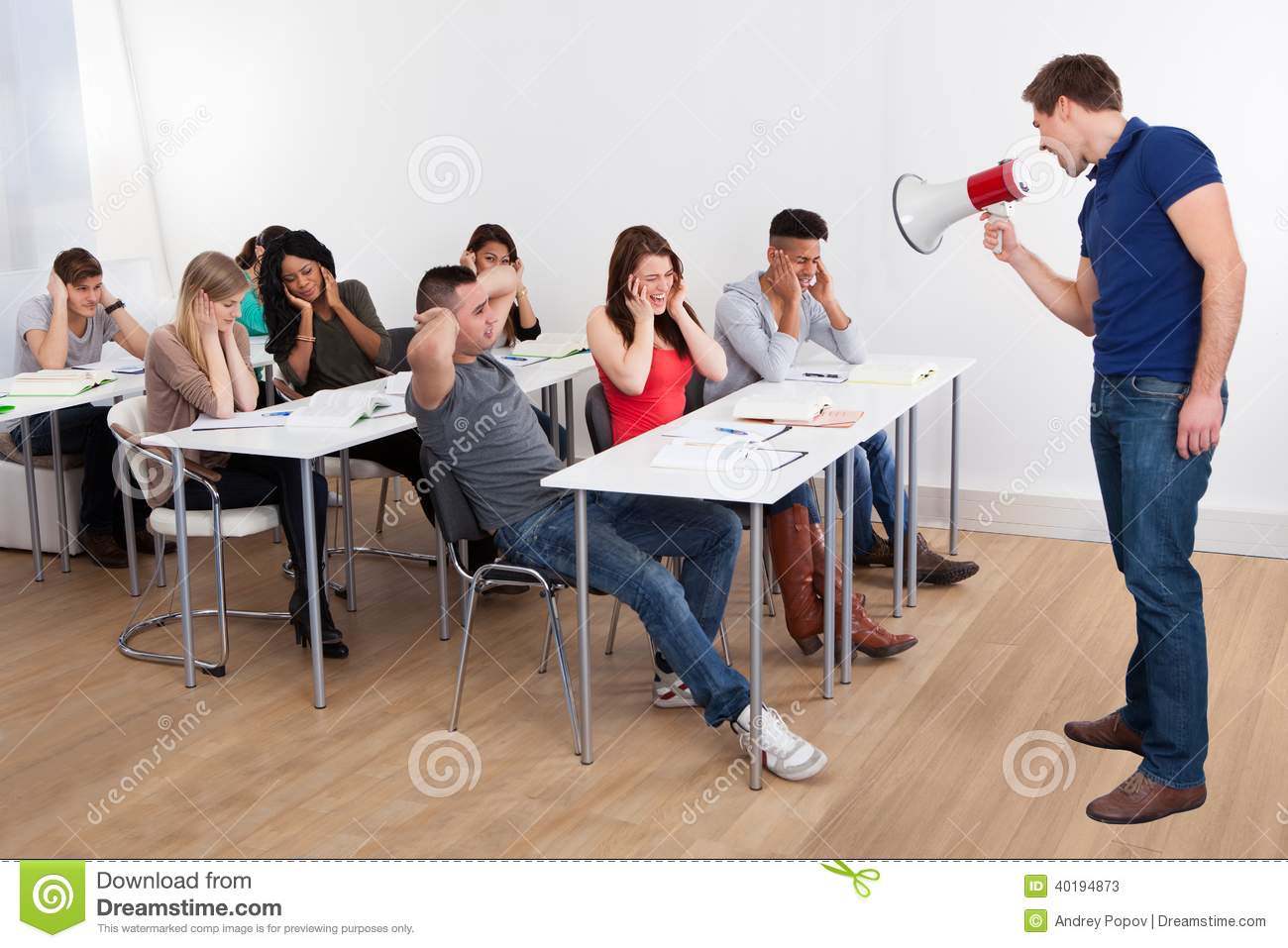 Teacher Shouting Through Megaphone On University Students Stock Photo