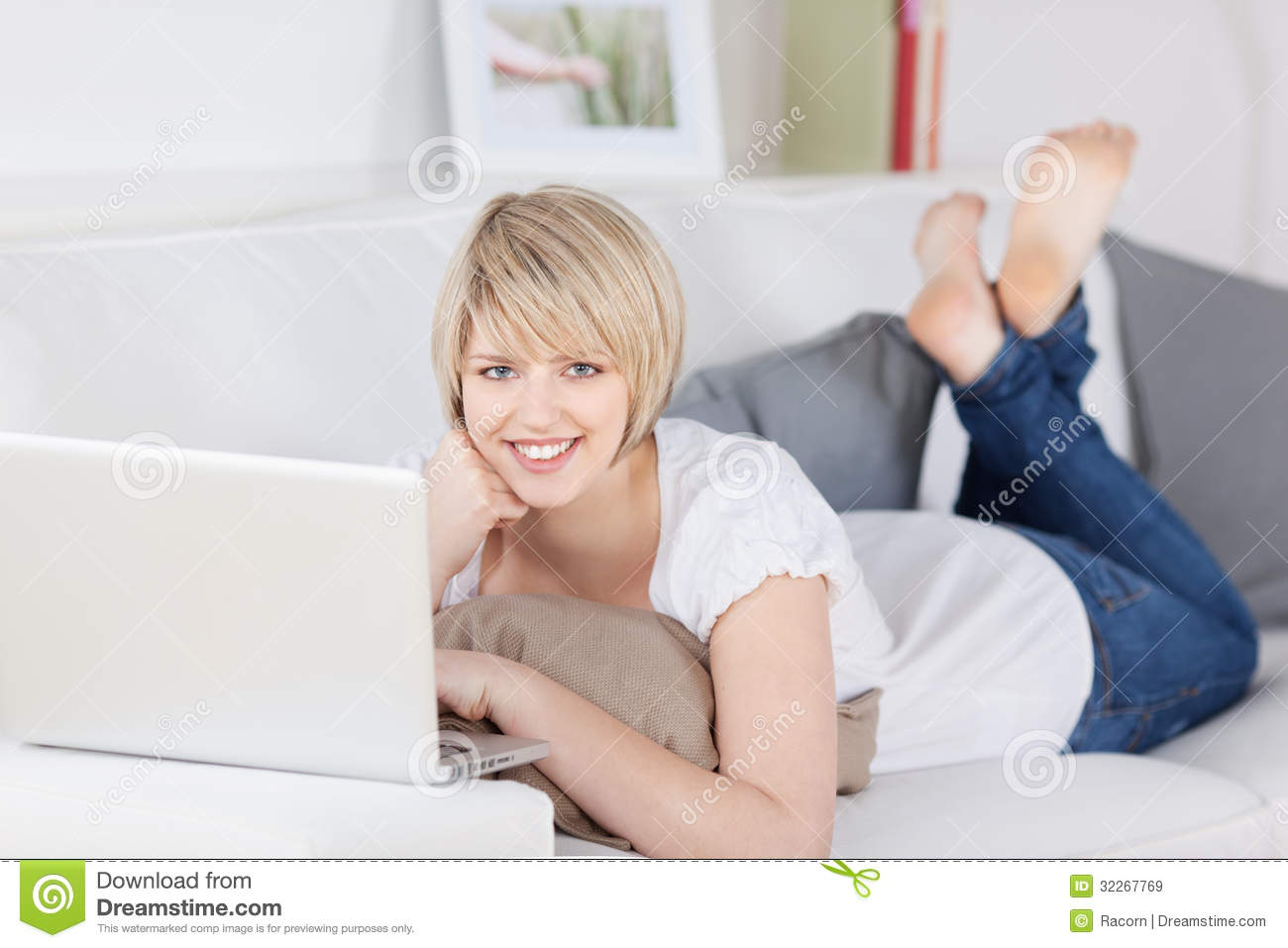 Friendly Young Woman With A Laptop On A Sofa Royalty Free Stock Images