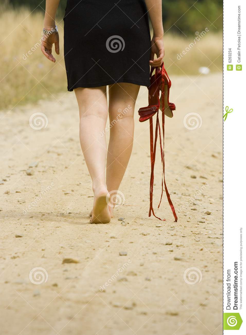 Portrait Of A Barefoot Woman Holding Her Red Sandals 