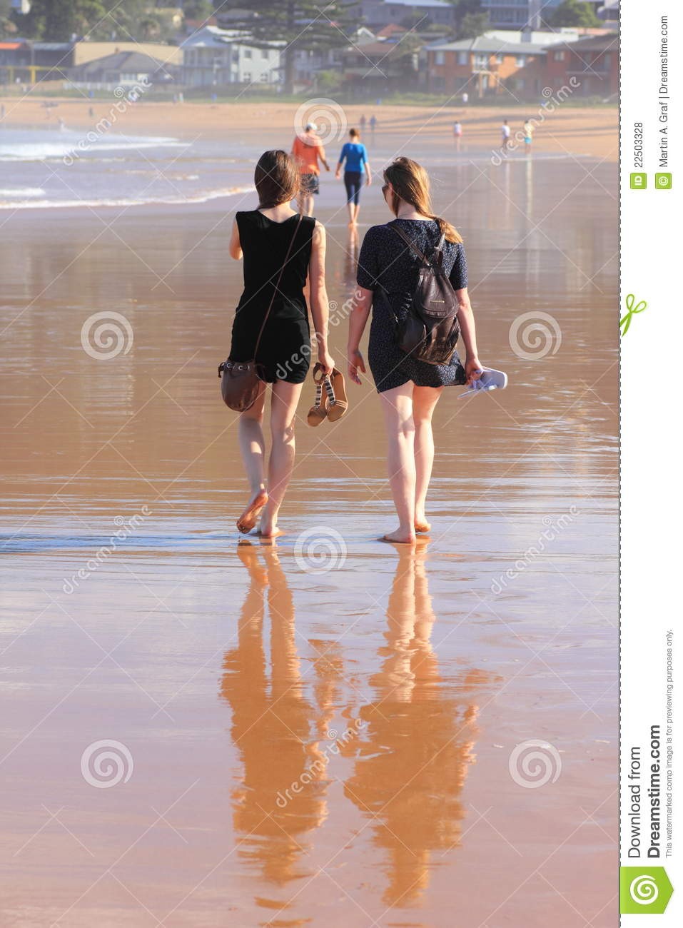 Two Women Mother And Daughter Talking And Walking Relaxed On A Beach