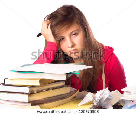 Tired And Stressed Teenage Girl Surrounded By Books Doing Homework    