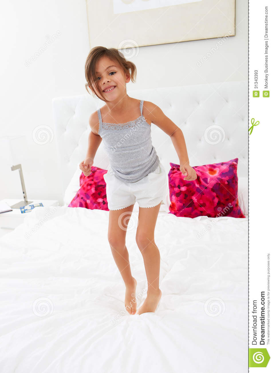 Girl Jumping On Bed Wearing Pajamas Stock Photos   Image  31343393