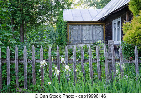 Old Wooden Country House With Porch And Rustic Wooden Fence And Flower