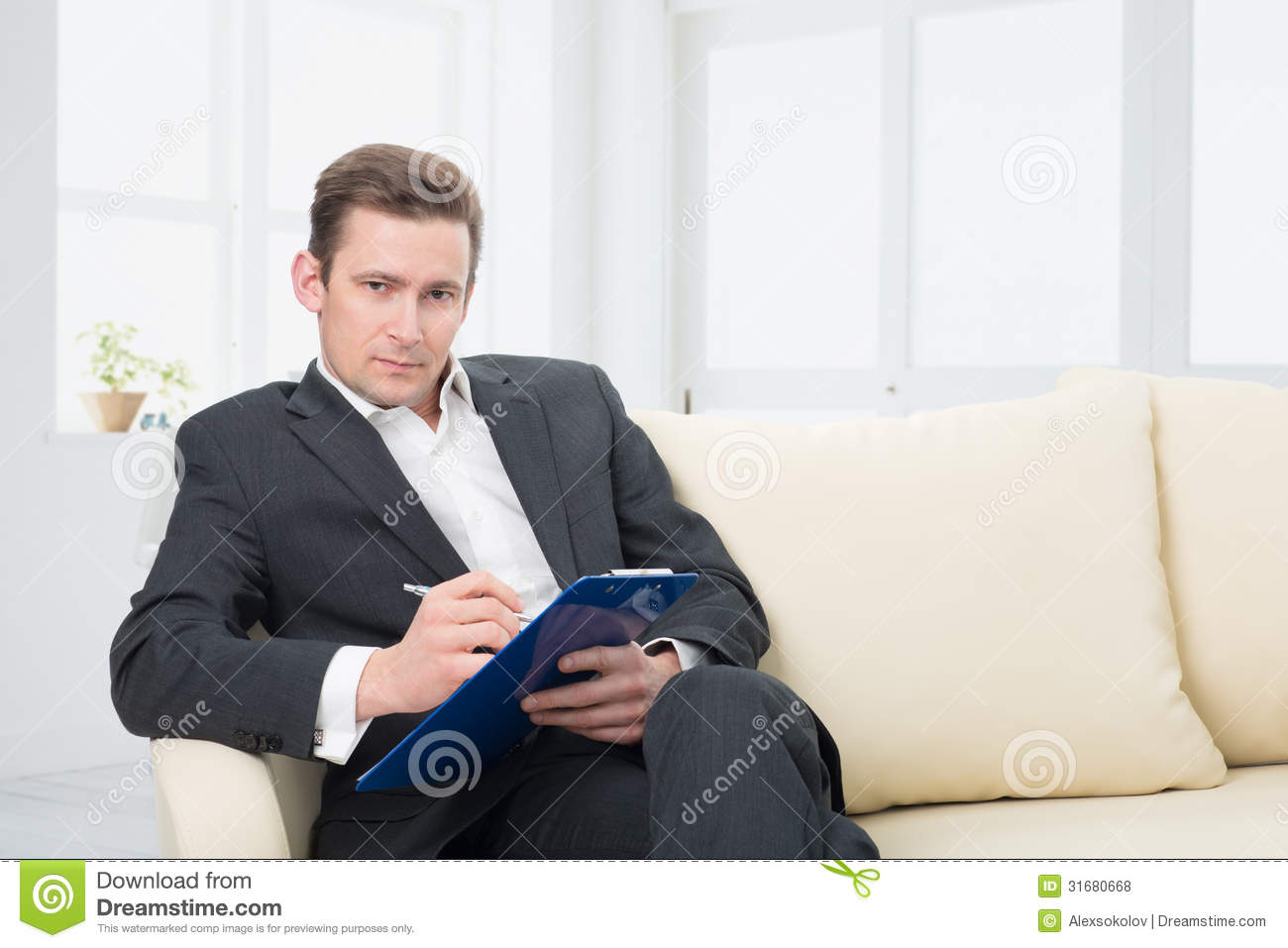Male Psychologist Being Ready To Take Notes Sitting On The Couch