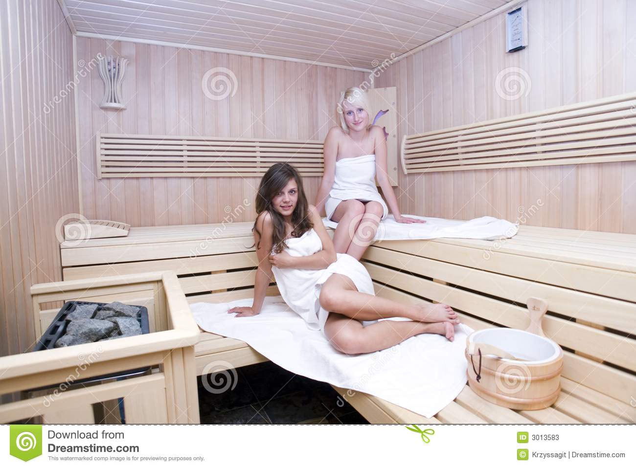 Wrapped In White Towels Relaxing In A Sauna Wooden Steam Room