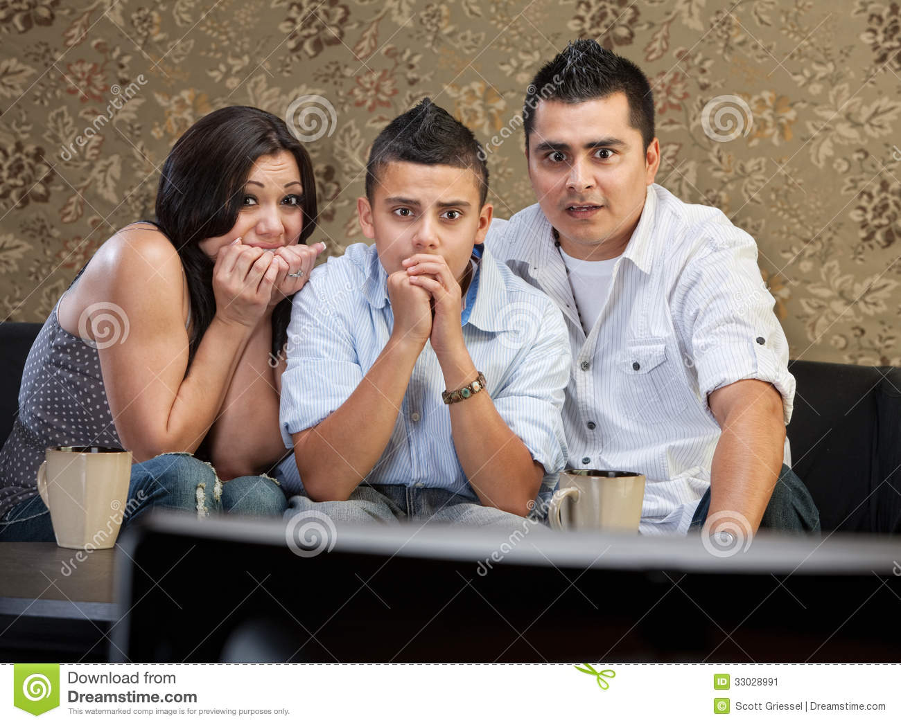 Scared Young Latino Family Watching Television Together