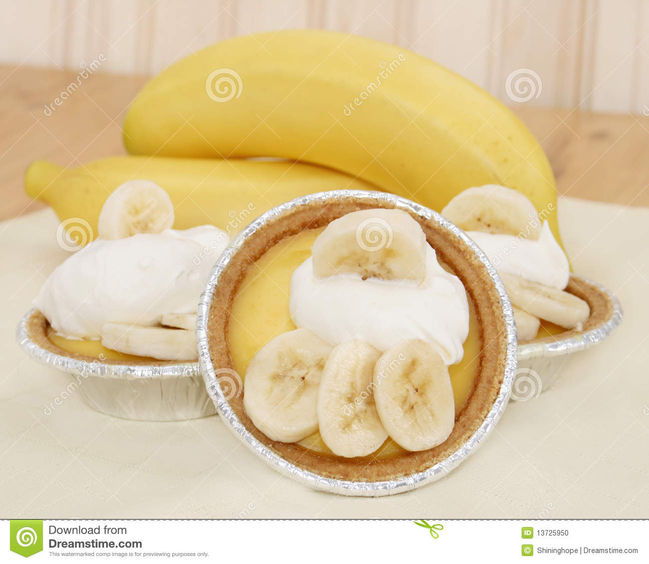 Three Mini Banana Pudding Pies With Banana Slices And Whipped Topping 