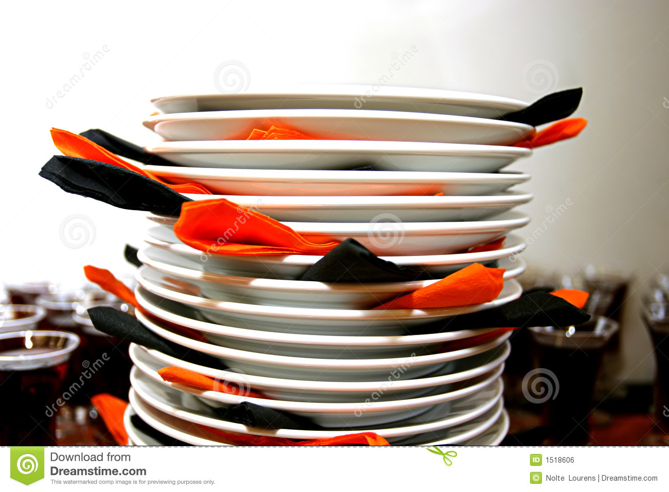 Plates Stacked Ontop Of Each Other With Orange And Black Napkins