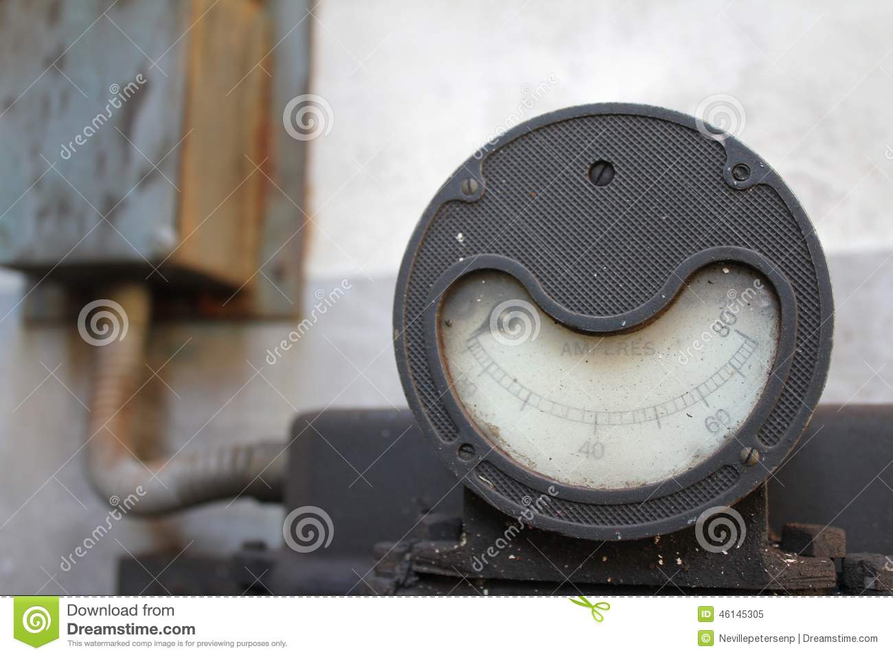 An Old Amp Meter With A Textured Metal Plate And Wide Smile Shape    