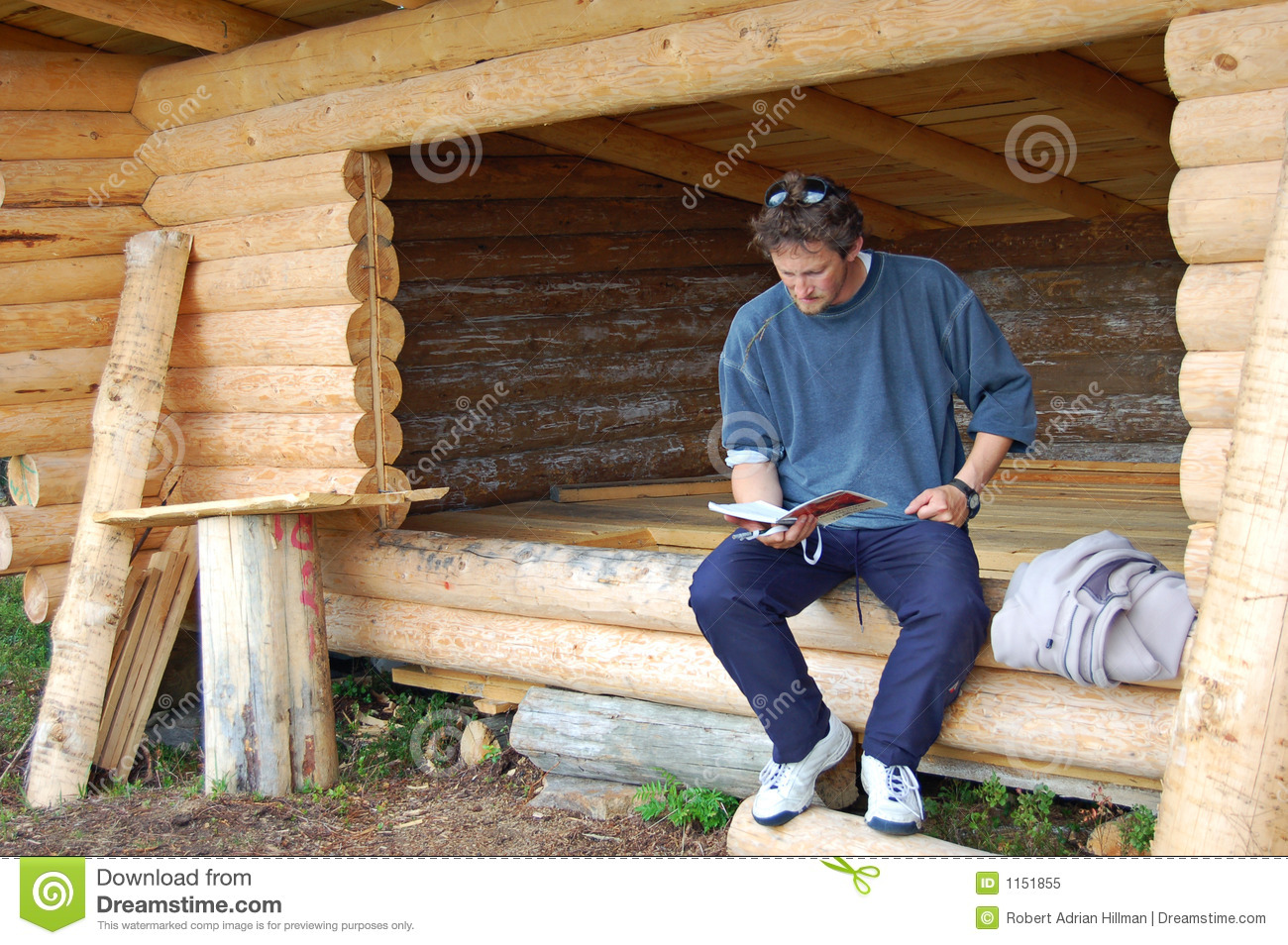 Man Sitting In A New Log Lean To Shelter 