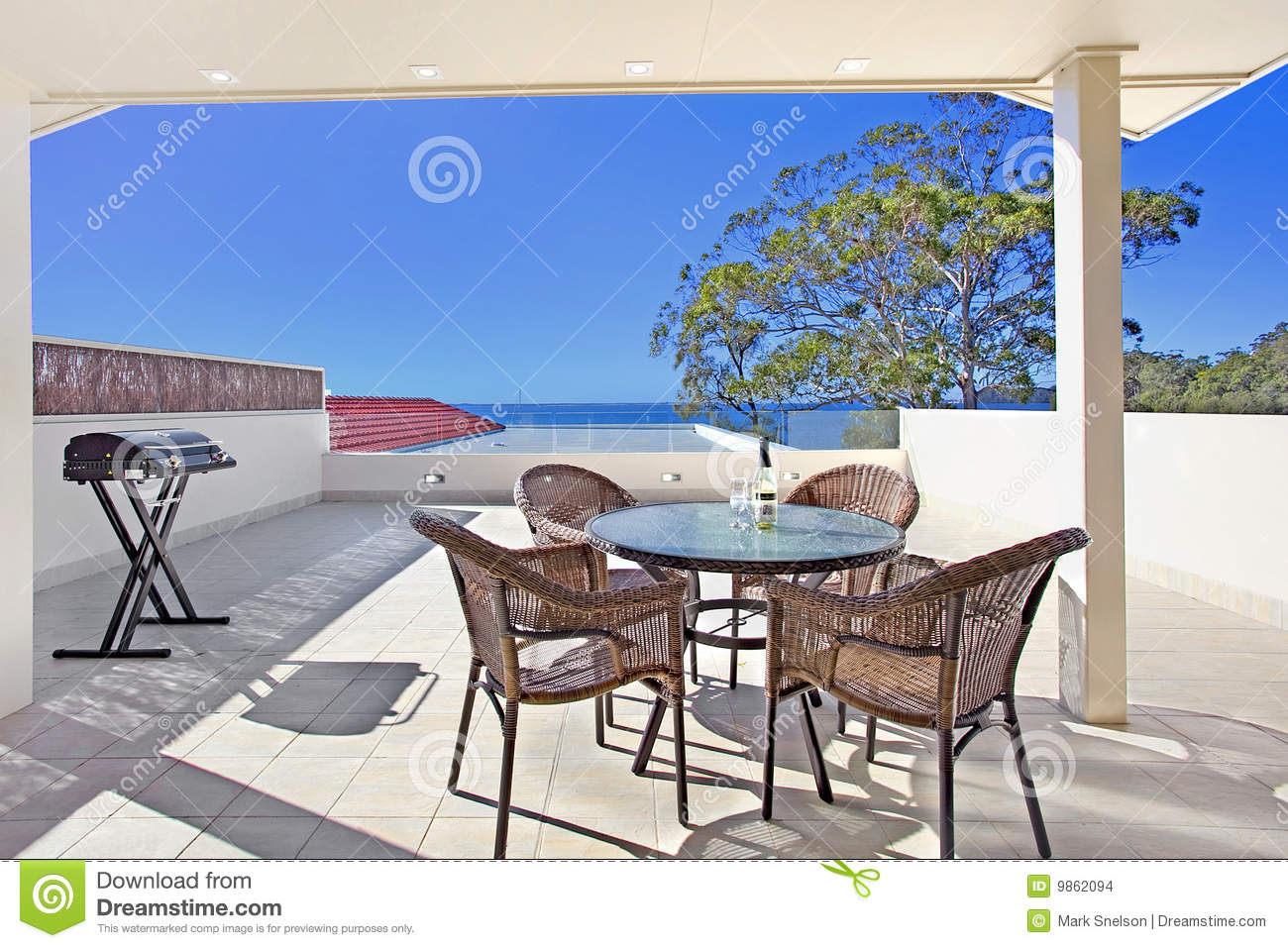 Balcony With Table And Chairs In A Waterfront Apartment