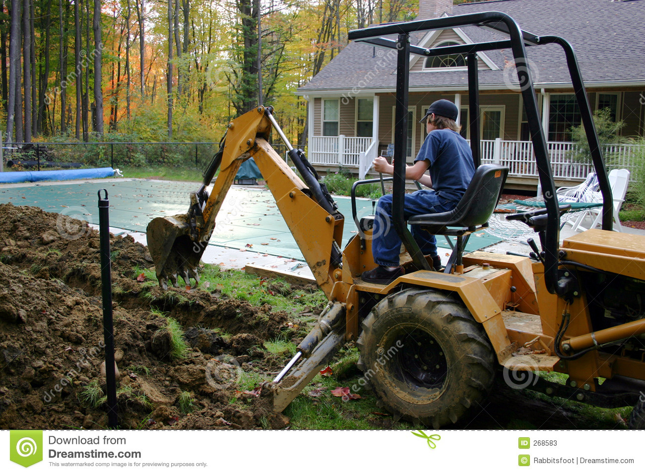 Teen Male Operating Backhoe In A Residential Backyard Project