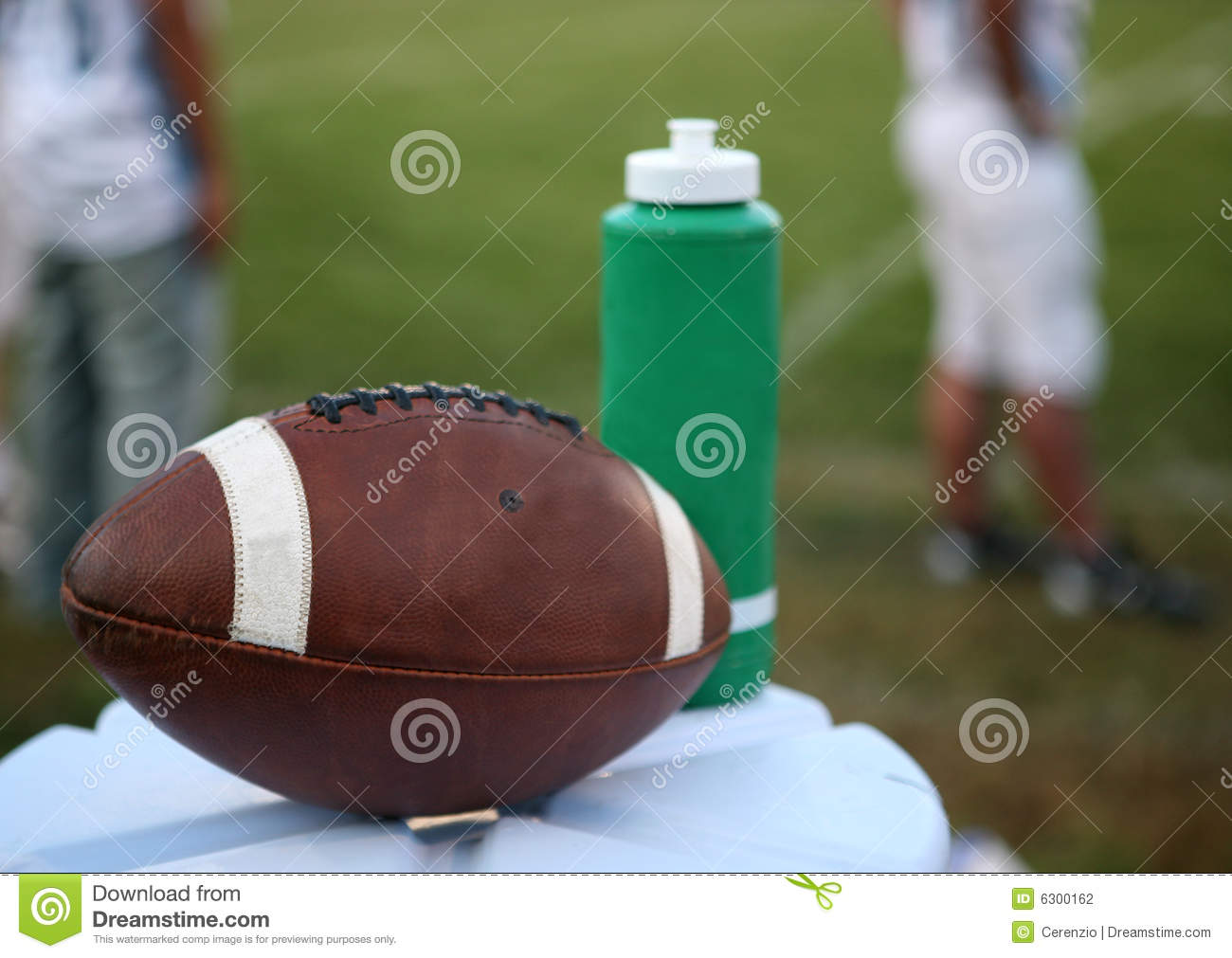 Football Resting On The Top Of A Water Jug Next To A Sports Water