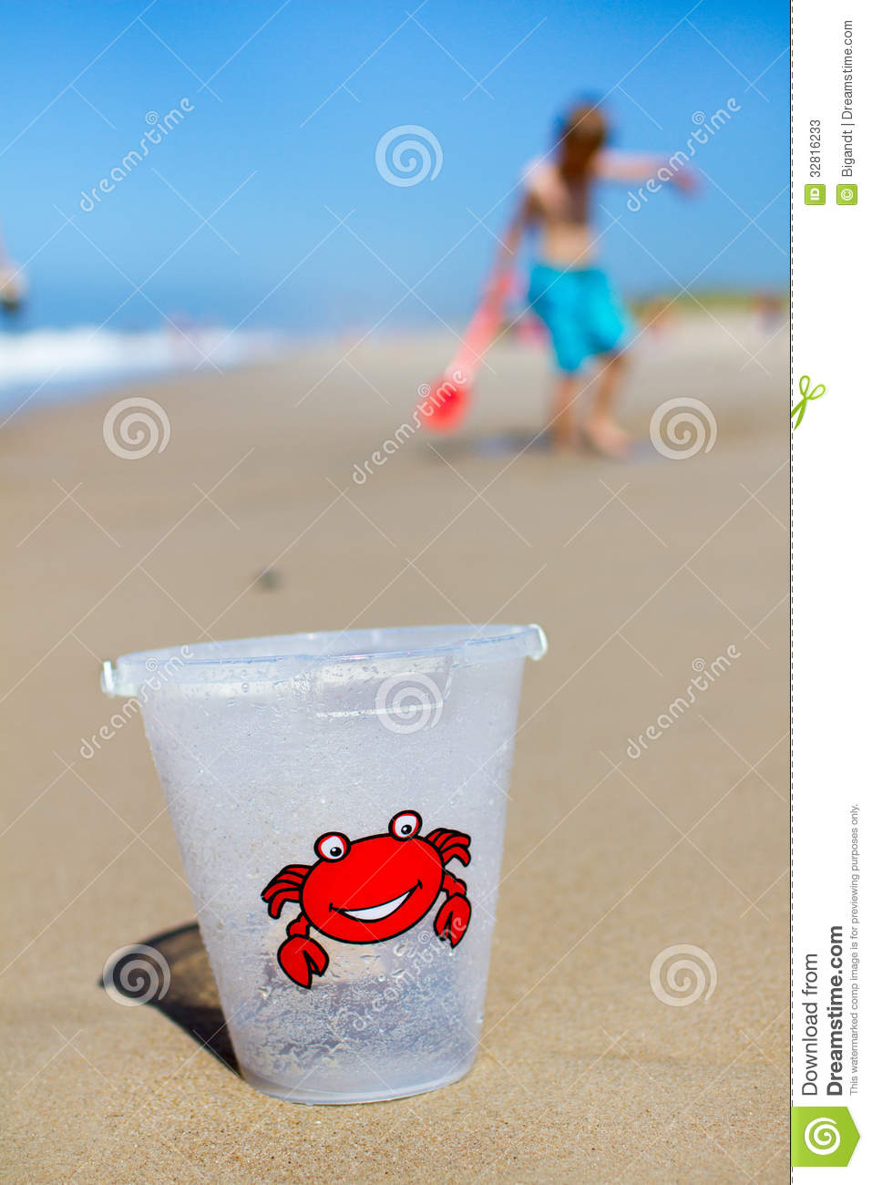 Plastic Toy Bucket With Red Crab On The Front Is In Focus In Front Of