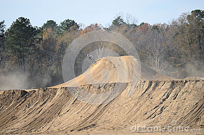 Dirt Bike Riding On The Side Of A Large Dirt Hill At Busco Beach And