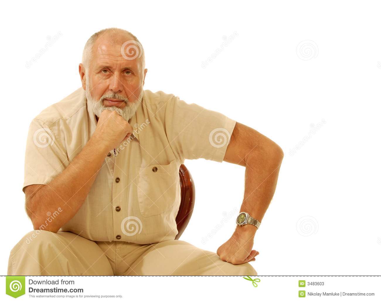 Serious Older Gentleman Sitting In A Chair  Isolated On White