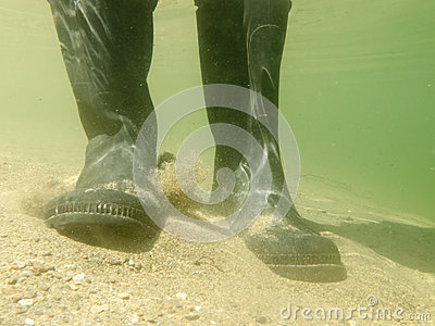 Closeup Underwater View Of Rubber Boots Gumboots Or Waders Of A Person    