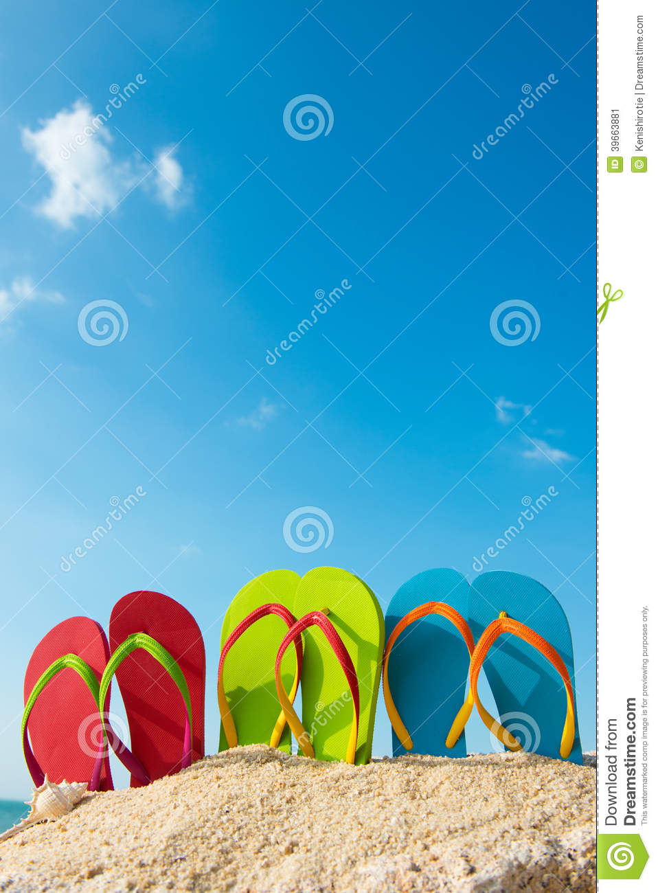 Row Of Colorful Flip Flops On Beach Against Sunny Sky 