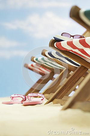 Row Of Deck Chairs On Beach Focus On Flip Flops On Ground Royalty Free    
