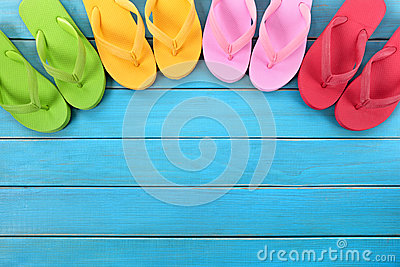 Semi Circle Of Colorful Flip Flops On Old Weathered Blue Painted Beach    
