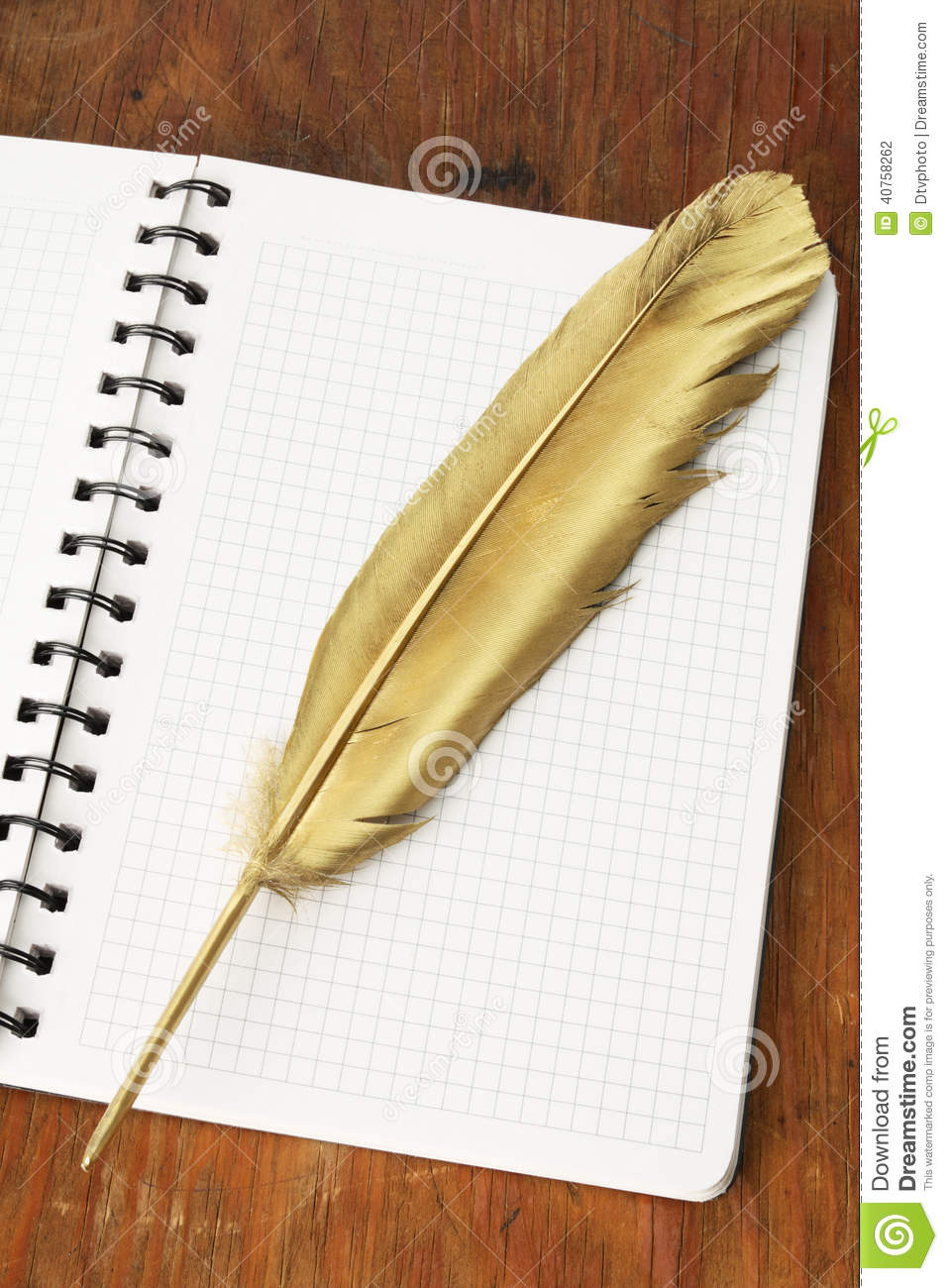 Gold Quill Pen Of Firebird On A Notebook And Wooden Table