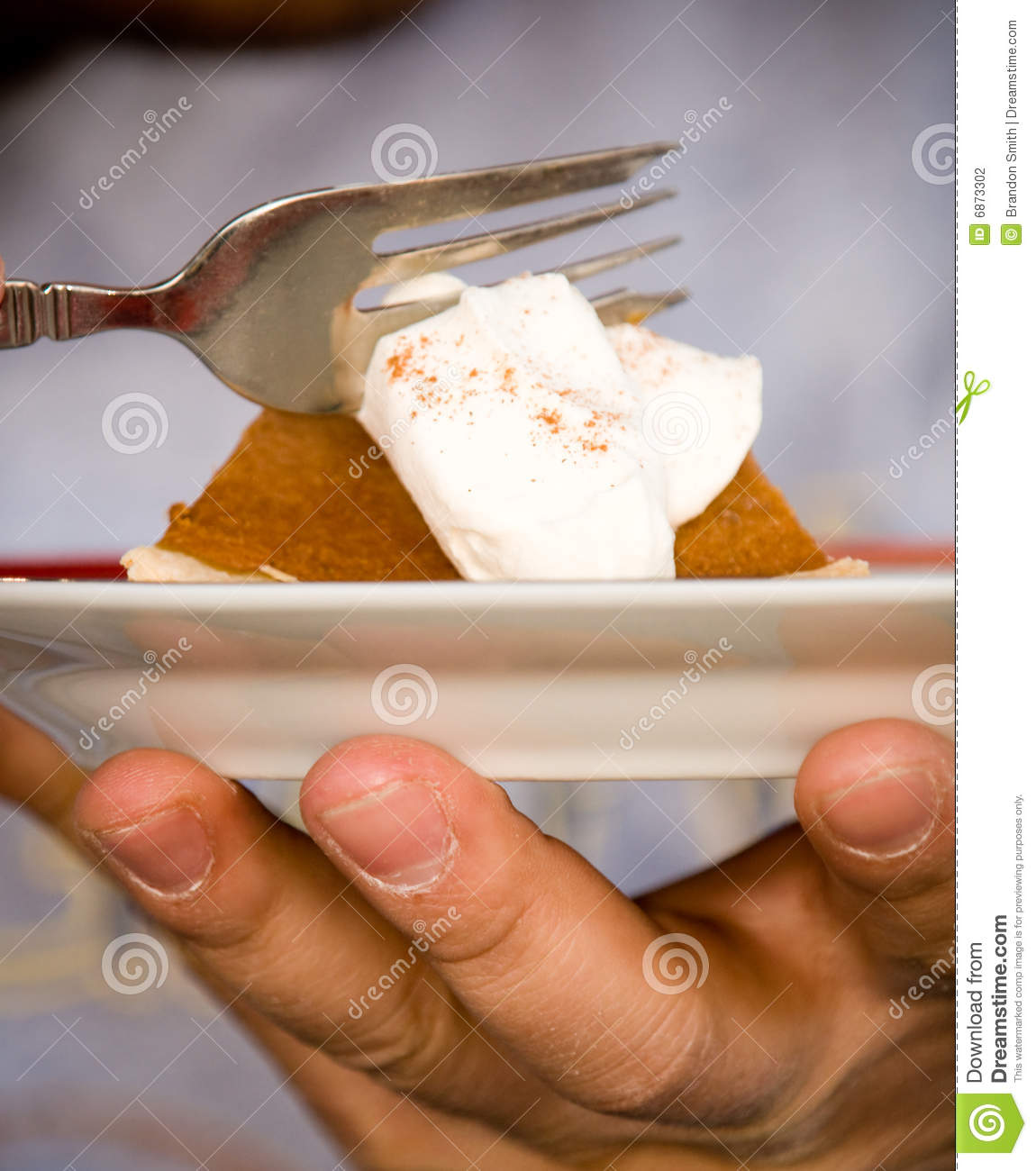 Man Holding A Plate And Eating A Piece Of Pumpkin Pie With Whipped    