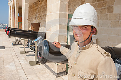 Dressed In Old English Military Uniform Standing In Front Of Cannons