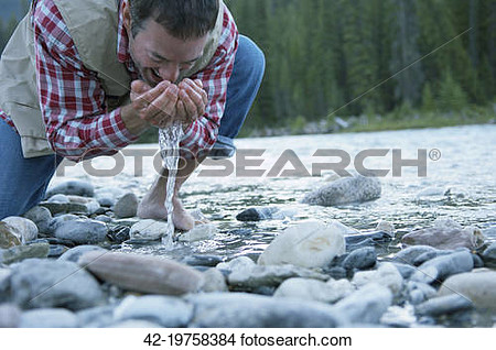 Stock Photo   Man Drinking River Water  Fotosearch   Search Stock