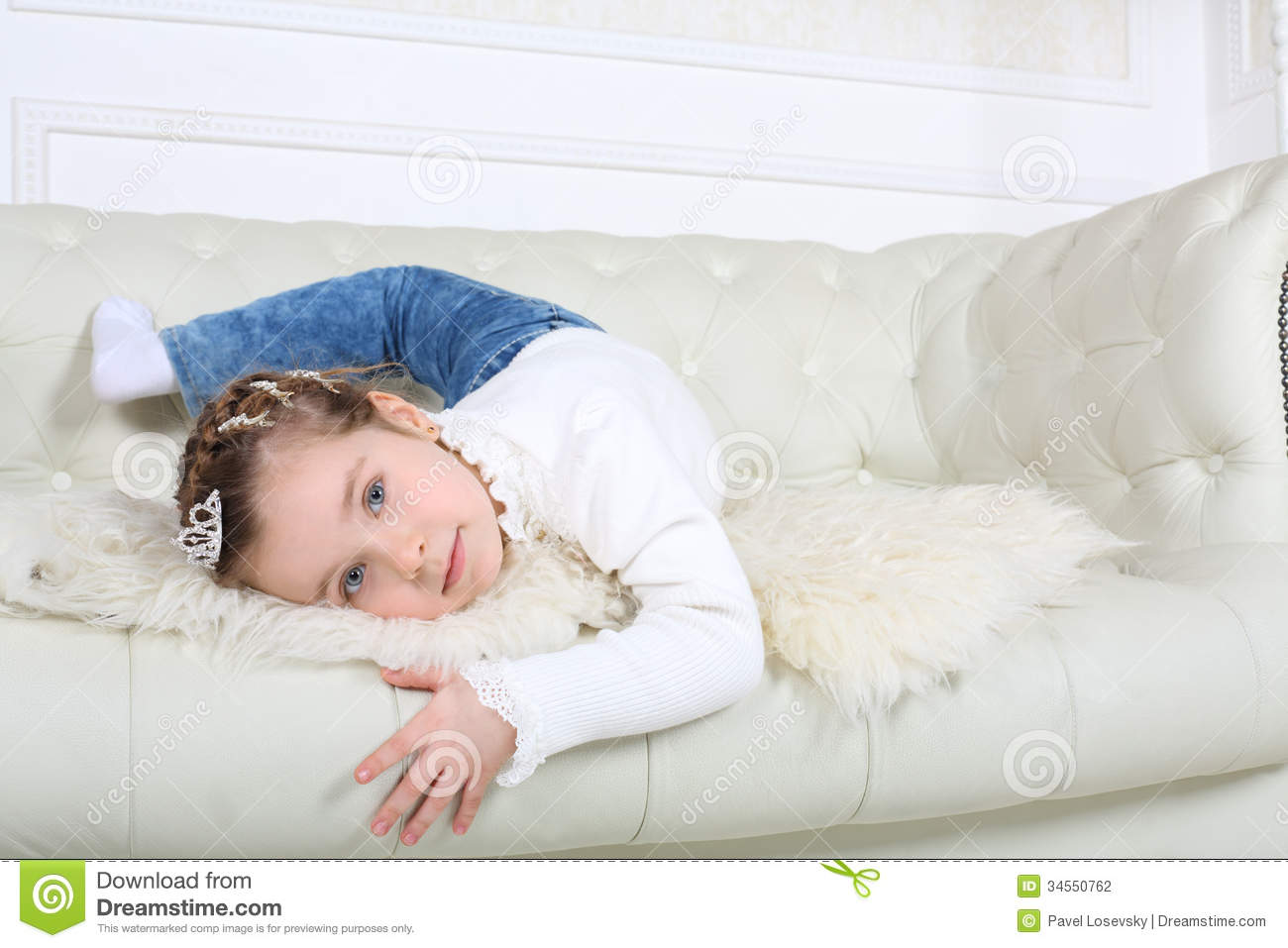 Stock Photography  Little Happy Girl In Jeans Lies On White Leather