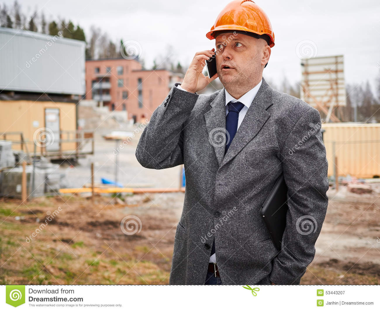 Male Engineer Uses Cell Phone He Wearing The Suit And The Hard Hat    