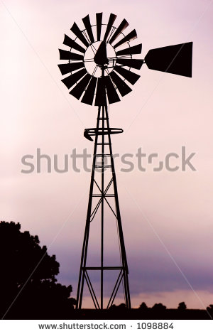 Silhouette Of A Working Vintage Country Windmill In Sunset Light Or