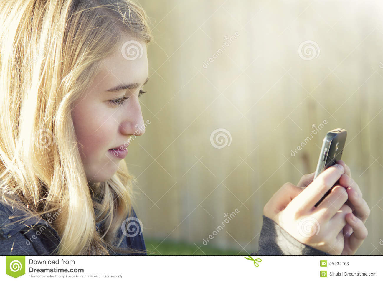 Girl Using A Cell Phone Texting Surfing The Internet Or Playing