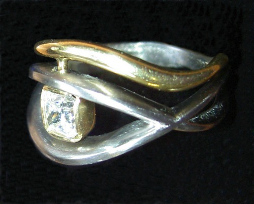 Wedding Ring That Flows Around The Diamond Of A Gold Engagement Ring