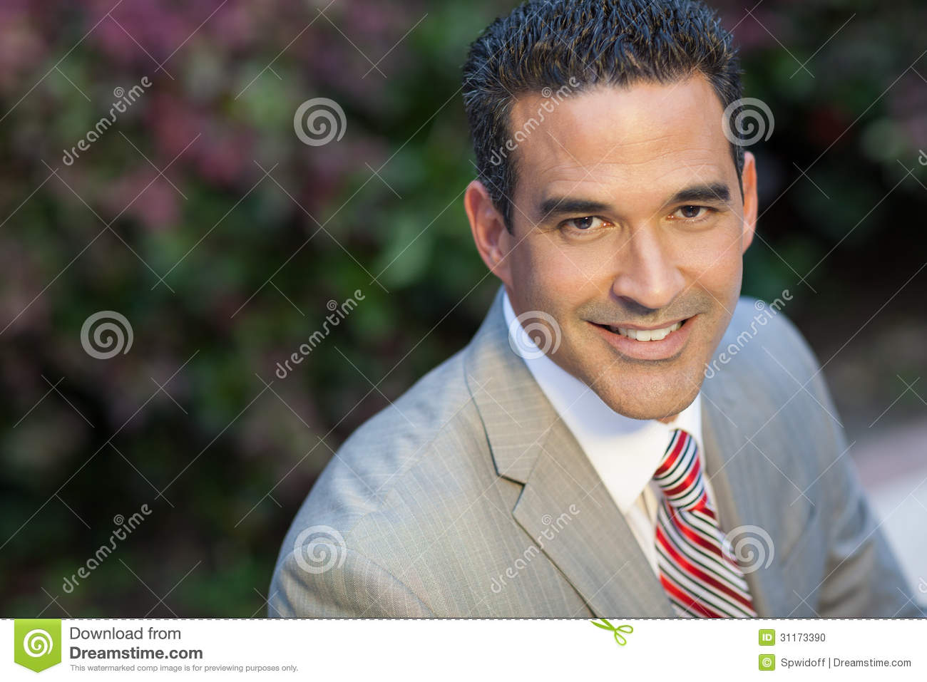 Handsome Brunette Hispanic Man Smiling At The Camera Outside In Suit