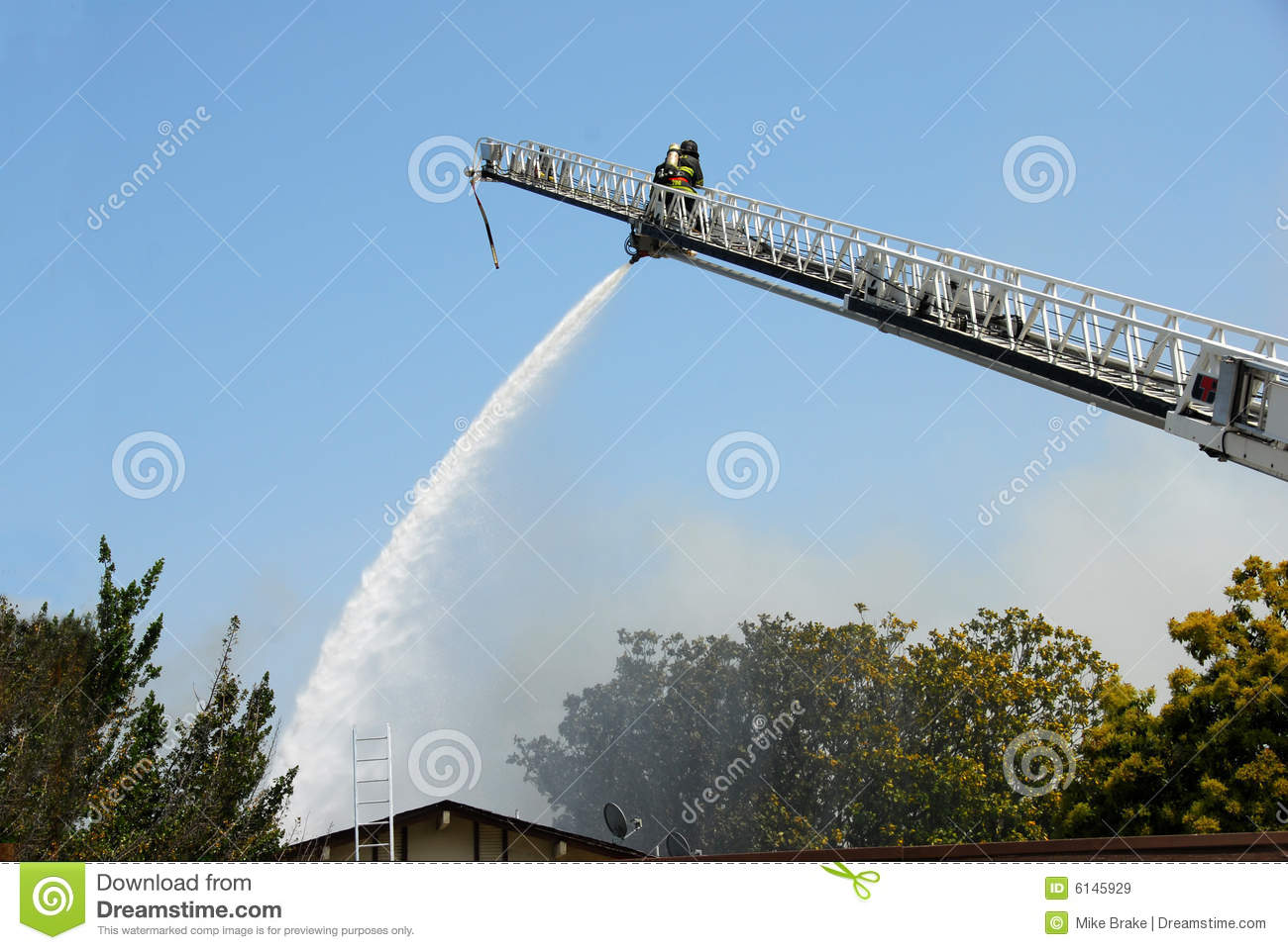 Fireman Using Water Cannon From Ladder Royalty Free Stock Images