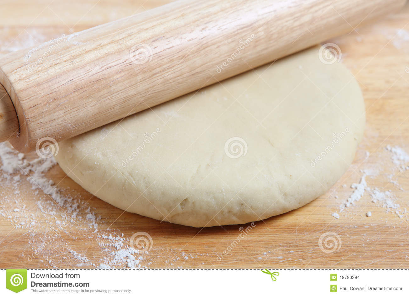 Rolling Out A Circle Of Pizza Dough With A Wooden Rolling Pin