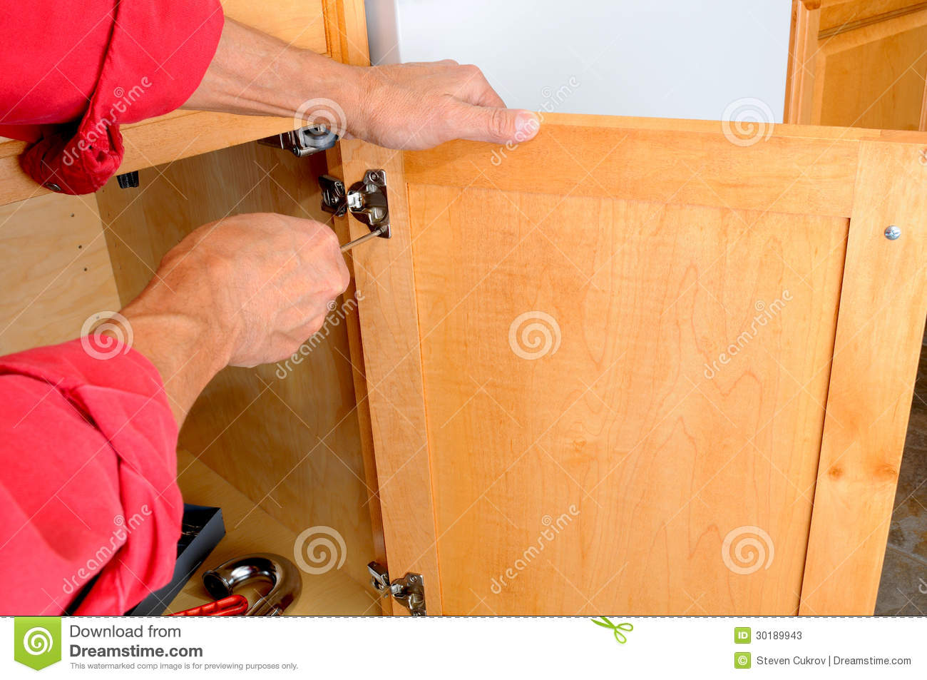 Closeup Of A Installers Hands Attaching A Hinge A Kitchen Cabinet