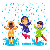 Kids In Raincoats And Rubber Boots Playing Royalty Free Stock Image