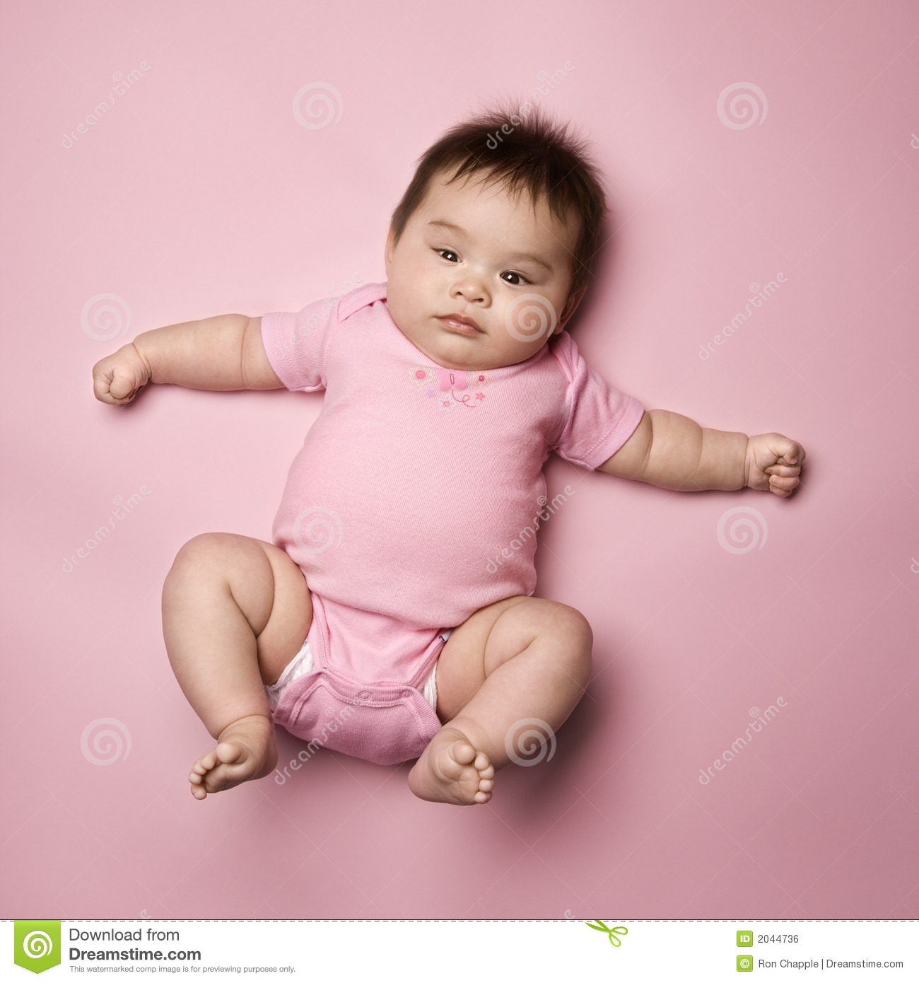 Asian Baby Lying On Back Lookin Up At Viewer With Arms Out To Side