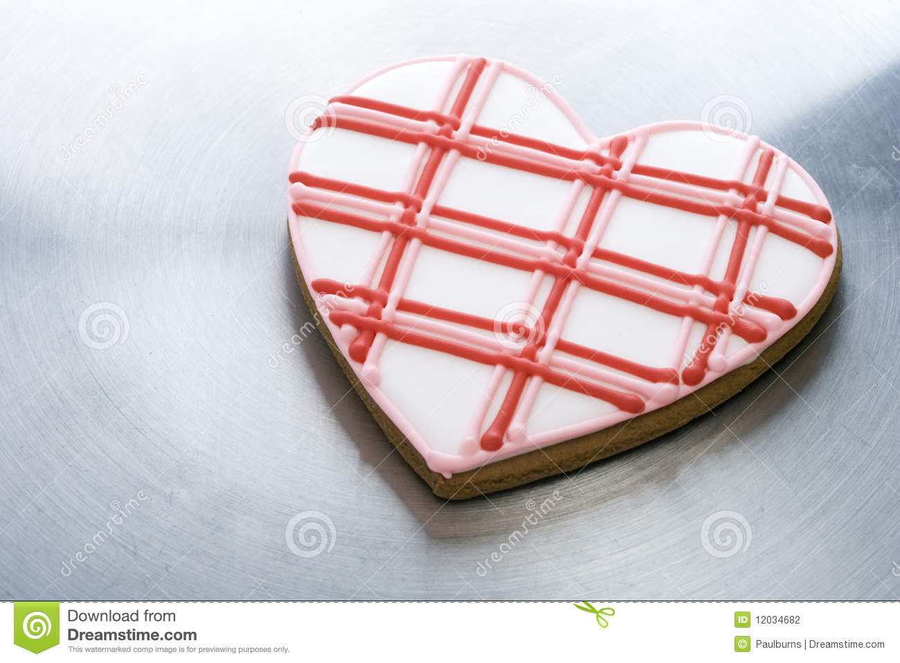 Heart Shaped Decorated Cookie Is Sitting On A Silver Surface