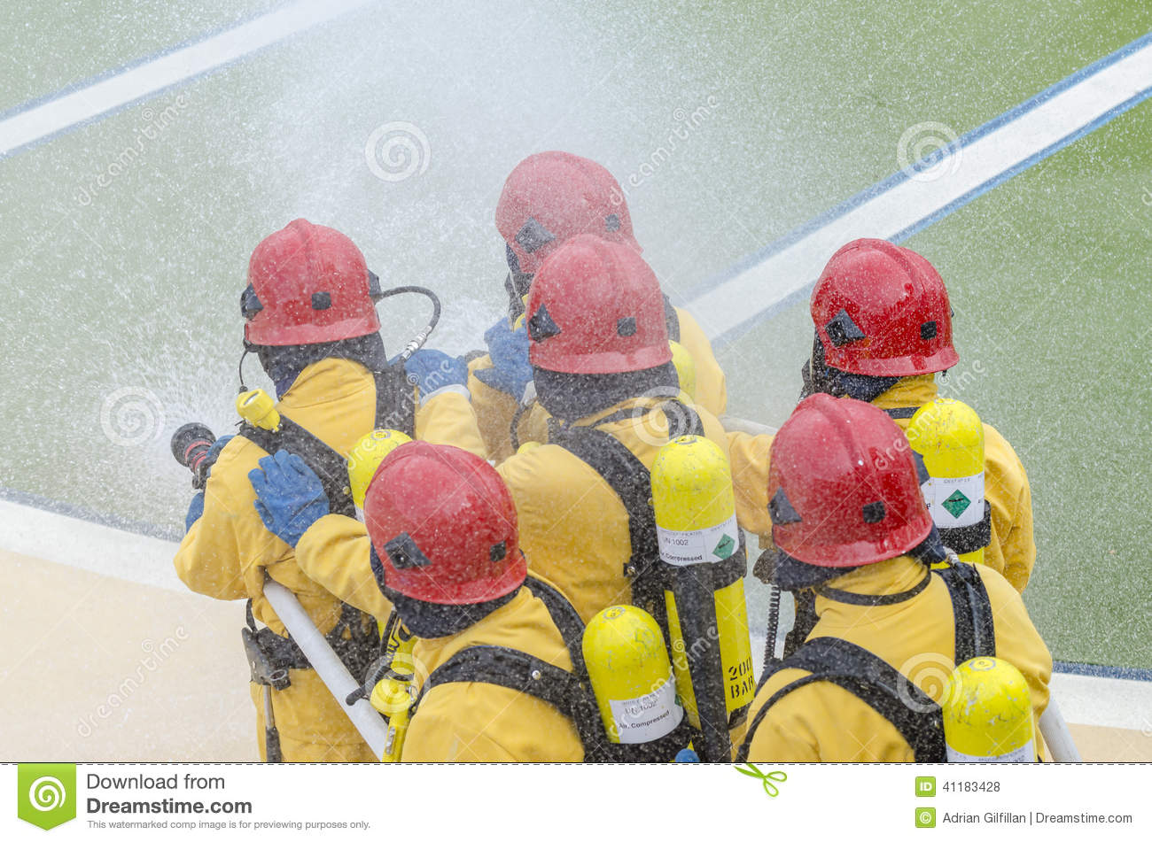 Team Of Firemen Spraying Water