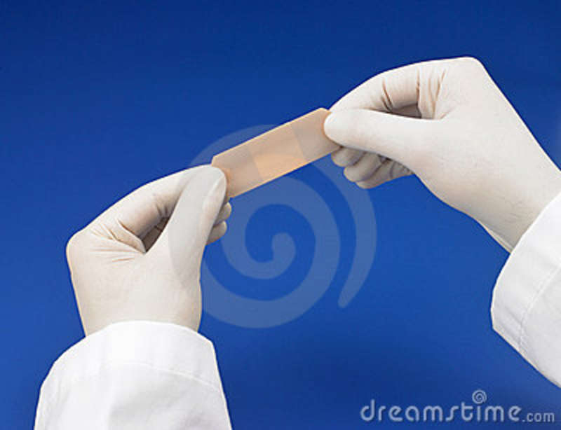Pair Of Gloved Hands Applying A Bandaid Against A Blue Background 