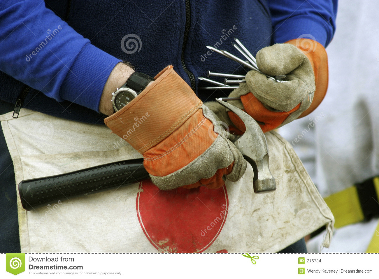 Pair Of Gloved Hands Holding A Hammer And Filling Work Apron Pockets
