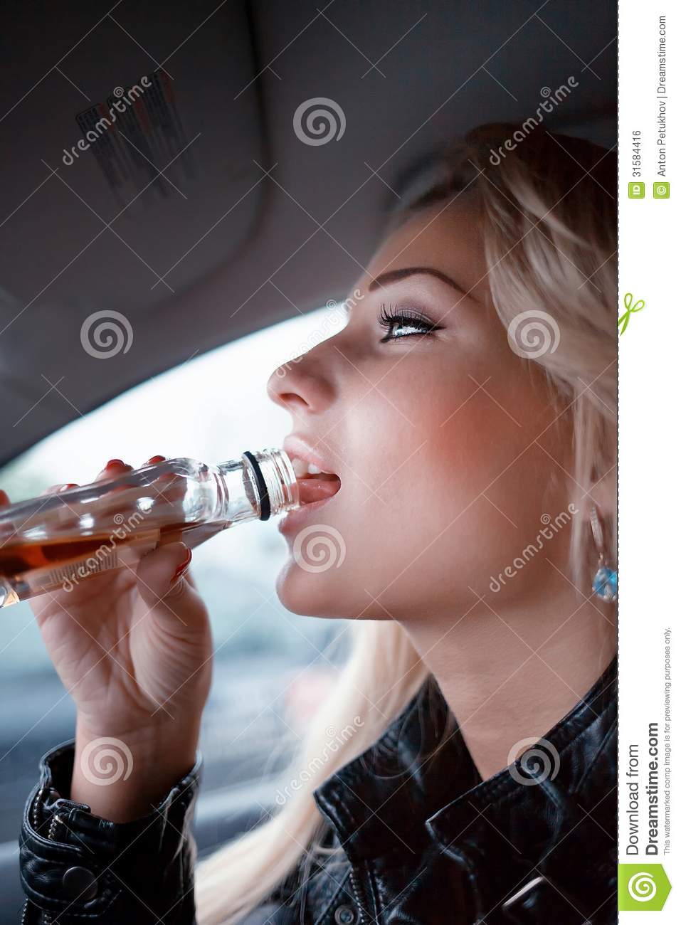 Side Portrait Of Young Blond Woman Drinking Bottle Of Whiskey In Car