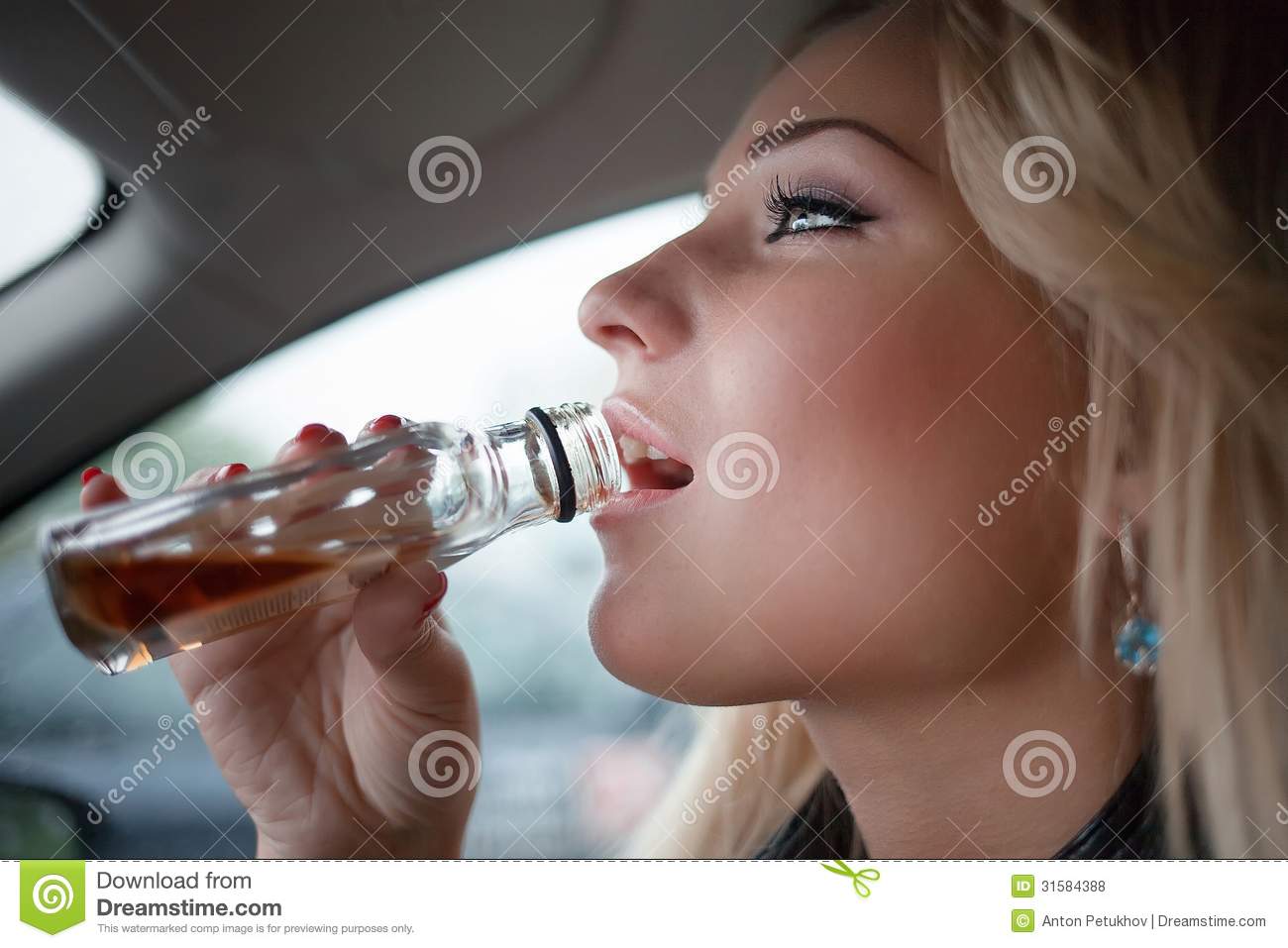 Side Portrait Of Young Blond Woman Drinking Bottle Of Whiskey In Car 